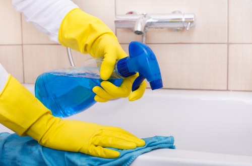 Trained carpet cleaner using protective gloves and footwear during a job